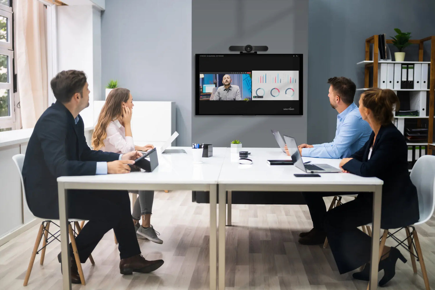 Personas sentadas en una sala de videoconferencia 