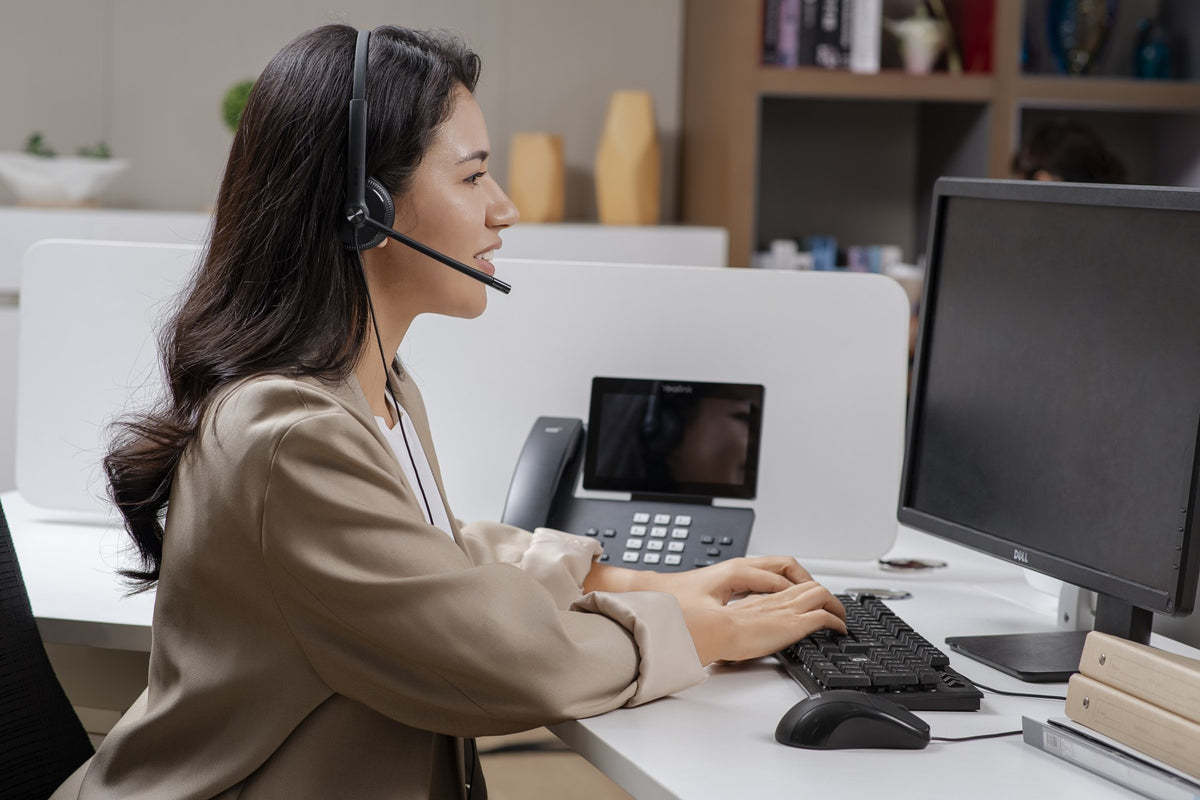 Persona usando audífono Yealink UH34 Mono en oficina para llamadas y videoconferencias